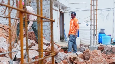 Worker lifting granite stone and kept side for basement work at construction Stock Footage 327721518