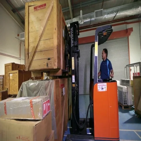 Worker lifting heavy box with the help of a machine Stock-Footage 69614383