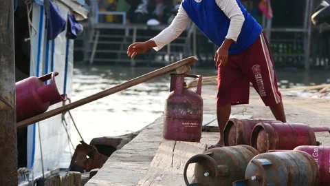 Worker lifting LPG cylinders onto ships. 4K Stock Footage 137720101