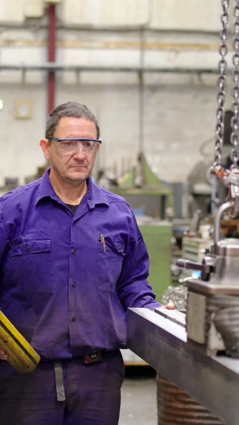 Worker lifting a piece of heavy metal in a factory Video stock 260577115