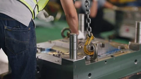 Worker lifts heavy metal mold with chain hook Stock Footage 341925657