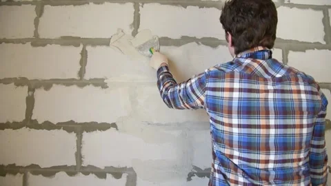 The worker lines the wall with white putty. Stock Footage 151194844