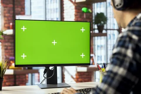 Worker listening music, analyzing data on green screen PC at desk Foto stock