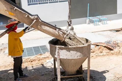 Worker load mixed concrete to basket for liftting pour on second floor. Foto stock