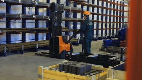Worker loading at forklift tubes stored in warehouse. Ready pipes on shelves Stock Footage 98681782