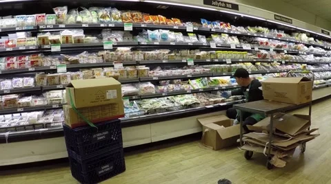 Worker loading goods on shelves in grocery store Stock Footage 44269882