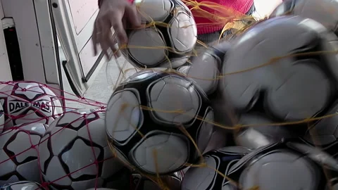 Worker Loading a Net Bag of Soccer Balls Onto the Back of a Truck - 4K Stock Footage 278106553