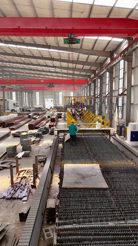 Worker loading sheet metal into laser cutting machine, factory, Almaty Stock Footage 335794846