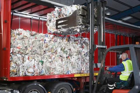 Worker Loading Stacks Of Recycled Papers On To Lorry Stock Photos