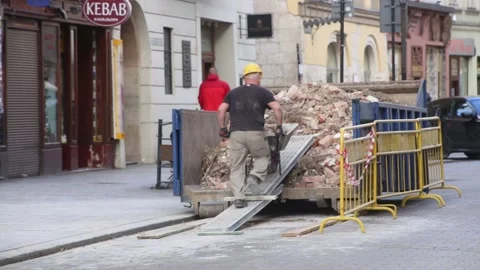 Worker loads builders rubble into a container. 3598 Stock Footage 142997146