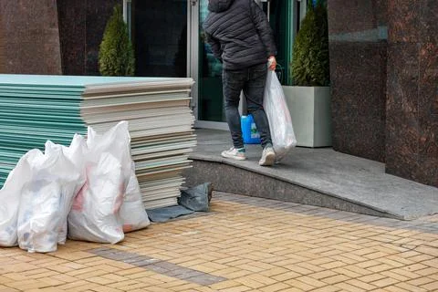The worker loads building materials and brings them into the entrance for fut Stock Photos