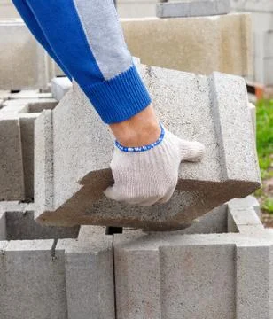 Worker loads cinder blocks  from cement slurry for construction Stock Photos