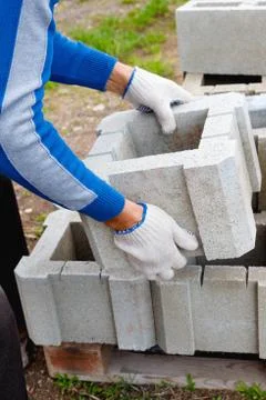 Worker loads cinder blocks  from cement slurry for construction Stock Photos