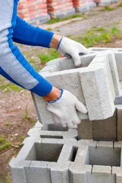 Worker loads cinder blocks  from cement slurry for construction Stock Photos
