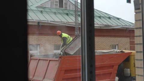 Worker loads material from container into dump truck Stock Footage 311105095