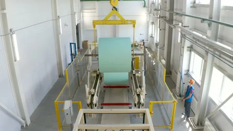 Worker loads a roll of paper on conveyor by crane. Manufacturing plasterboard Видео 138880014