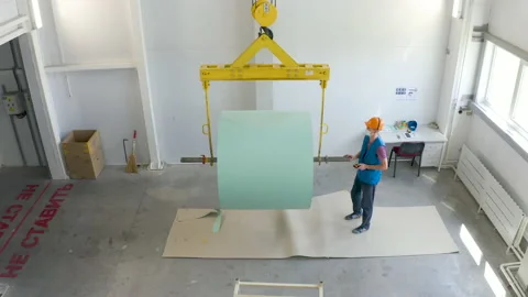 Worker loads a roll of paper on conveyor by crane. Eemployee in anti covid Stock Footage 138898190