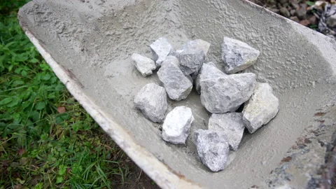 Worker loads wheelbarrow with stones Stock Footage 158974014