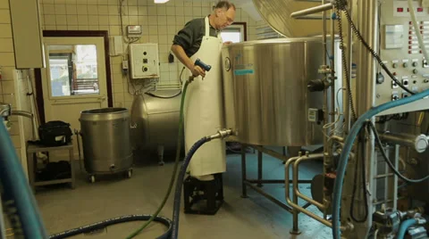 Worker is looking in a tank with milk Stock Footage 35331114