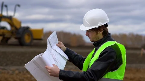The worker looks at the drawings on the background of the road under Video stock 100005485