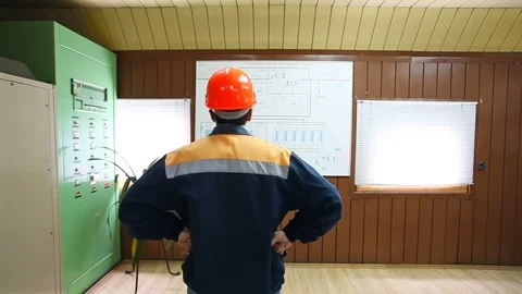 Worker looks at large scheme Stock Footage 88352834