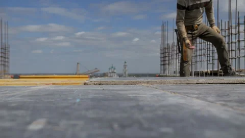 Worker lowering plywood sheet onto formwork Stock Footage 314058668