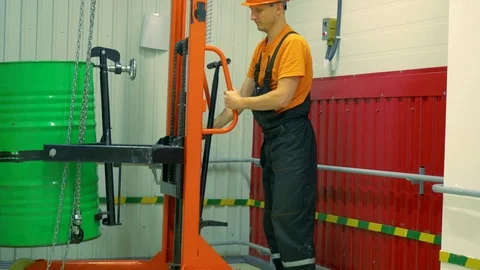 The worker lowers the barrel using a lifting mechanism. Stock Footage 86787647
