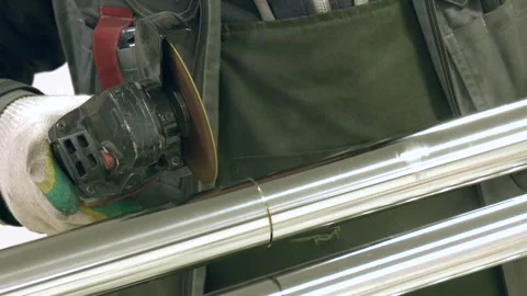 A worker is machining a stainless pipe with an angle grinder. 動画素材 300761145