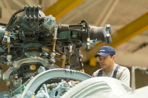 Worker maintaining helicopter engine. Tyumen Stock Photos