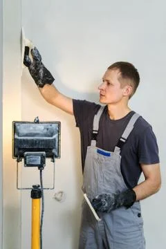 Worker makes final smoothing plaster on the wall. Stock Photos