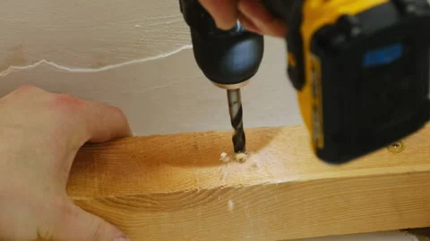Worker makes hole with electric drill in wooden plank 스톡 동영상 304403910