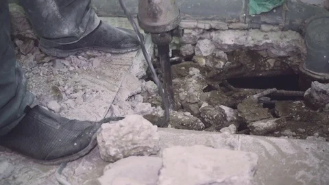 Worker makes a hole in the floor and removes bits of biton close-up Stock Footage 110801779