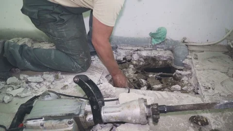 Worker makes a hole in the floor and removes bits of biton Stock Footage 110802083