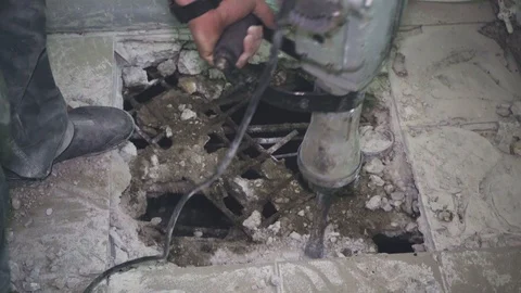 Worker makes a hole in the floor and removes bits of biton close-up Stock Footage 110803528