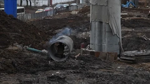 Worker makes hole in pipe using hammer Stock Footage 219884884