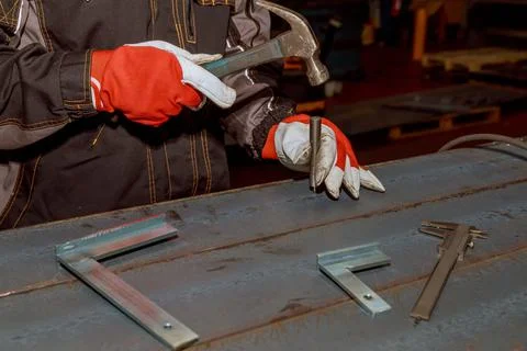 The worker makes a mark on a metal surface. Drilling holes in metal profiles for Stock Photos