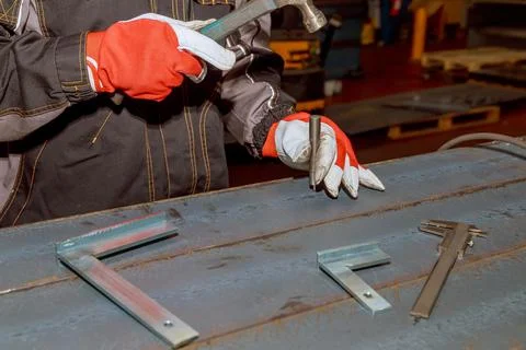 The worker makes a mark on a metal surface by means of Measuring square. Dril Stock Photos