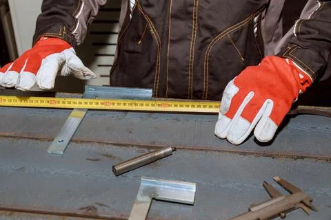 The worker makes a mark on a metal surface by means of Measuring square. Dril Stock Photos