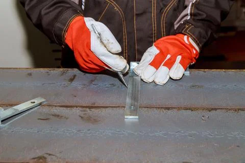 The worker makes a mark on a metal surface by means of measuring square Stock Photos