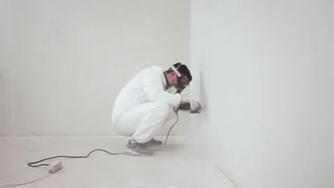 Worker makes repairs in apartment, saws wall with grinding machine, general plan Stockbeeldmateriaal 153871623
