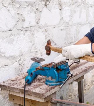 Worker makes repairs  with electric tools  hammer and  pliers in backyard of  Stock Photos