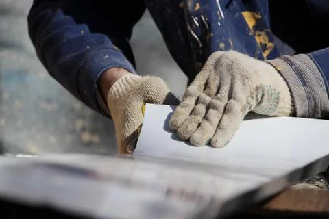 The worker makes the sladding of windows in the restored building in the city Stock Photos