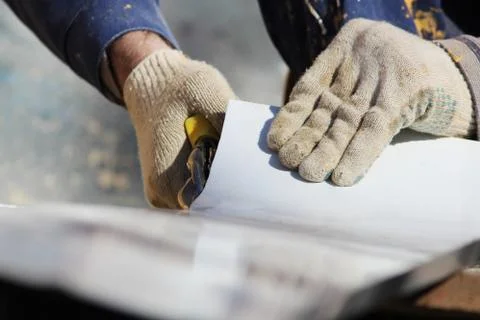 The worker makes the sladding of windows in the restored building in the city Stock Photos