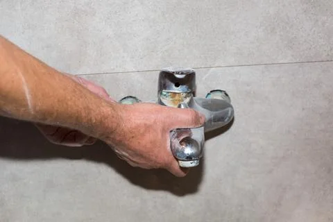 Worker is making Bath tap installation.  Maintenance repair in the flat. Re.. 스톡 사진