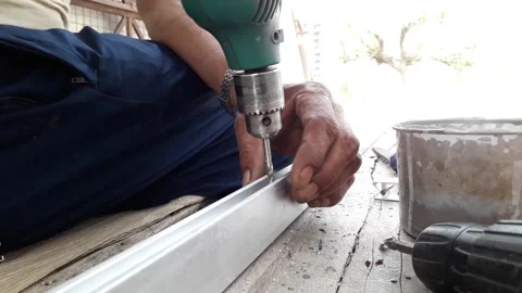 Worker making hole or drilling in metal using electric drill machine Stock Footage 136957770