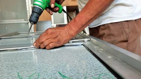 Worker making hole or drilling in metal using electric drill machine Stock Photos