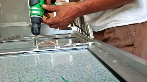 Worker making hole or drilling in metal using electric drill machine Stock Photos
