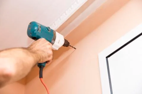 Worker making a hole in the wall Foto stock