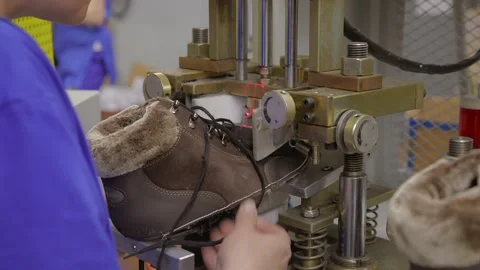 Worker making leather shoes on production line conveyor in production line of Stock Footage 155392250