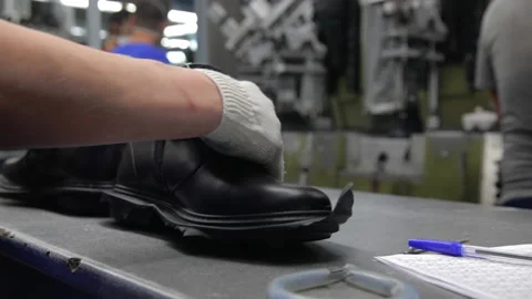 Worker making leather shoes on production line conveyor in production line of Stock Footage 155393058
